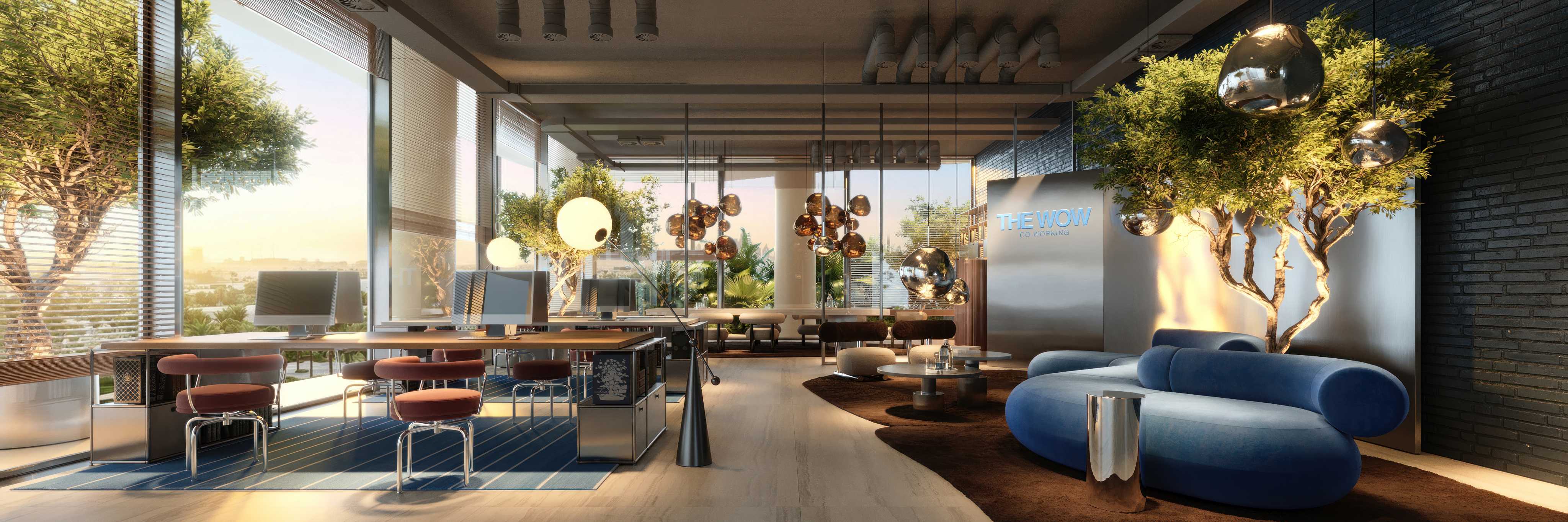 Coworking space with desks, computers, trees and a blue lounge sofa