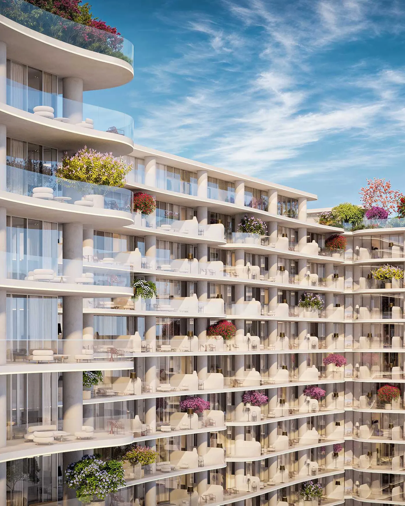 White tower facade with curving balconies and flowering planters